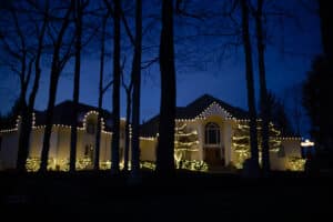 A beautifully lit Indianapolis home with roofline and tree lights installed by Indy Christmas Light Pros, showcasing outdoor tree lighting safety during winter weather.